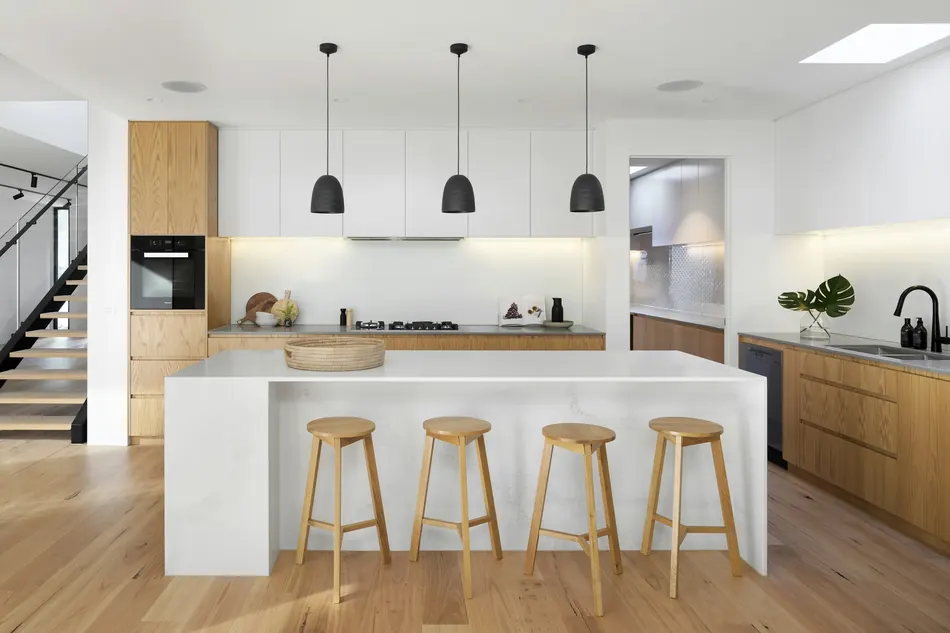 A kitchen island with pendant lighting and an undermount sink.